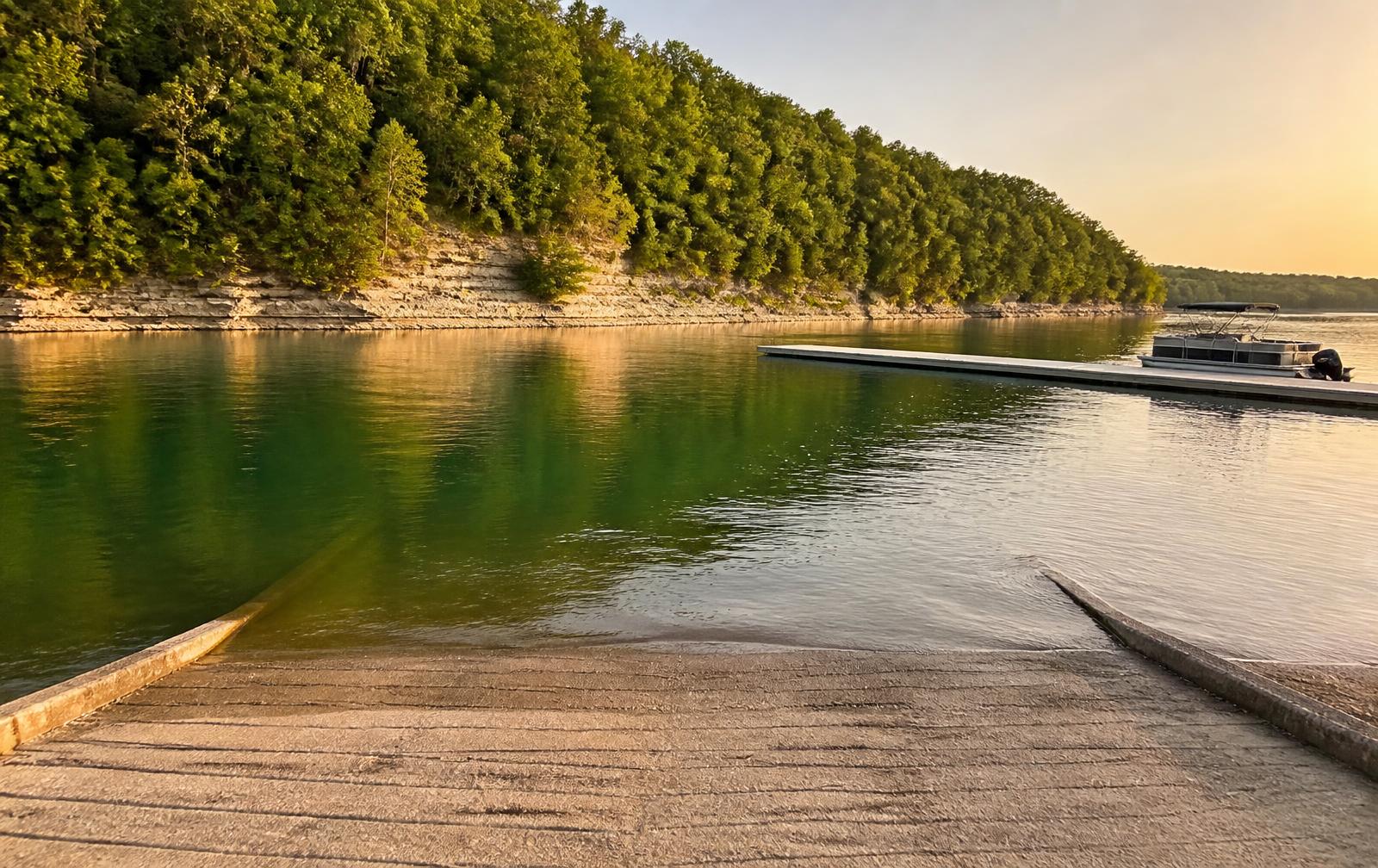 Lake Cumberland cove with limestone bluffs, a boat ramp and a pontoon boat